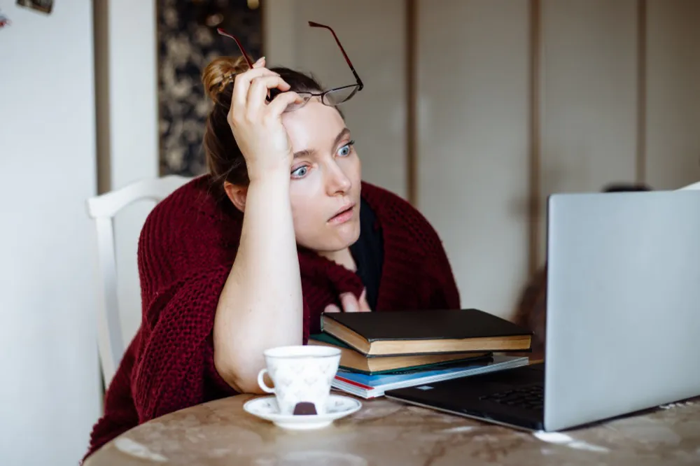 Frau sitzt ersch&ouml;pft am Schreibtisch